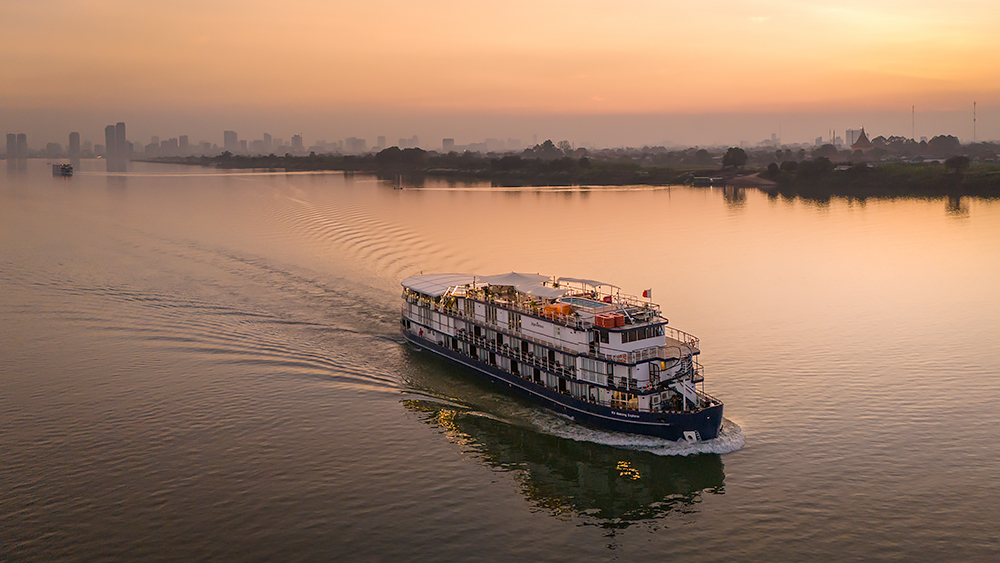 Aerial view of a luxury cruise ship and Phnom Penh skyline in the distance | Drone and Aerial Photography