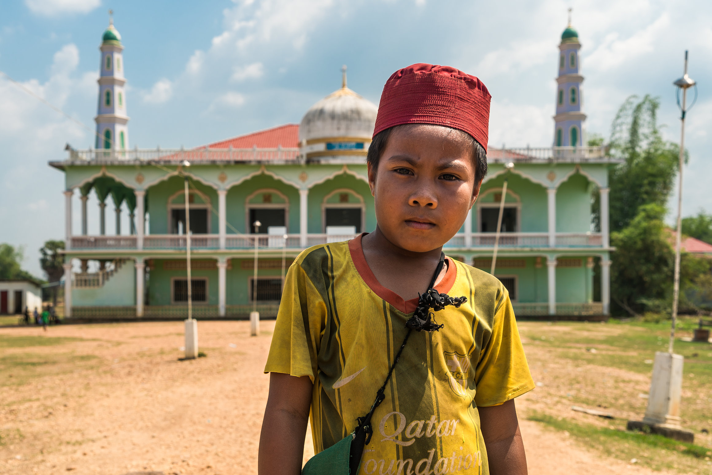 Portrait of a Cham muslim kid in front of a mosque in Cambodia