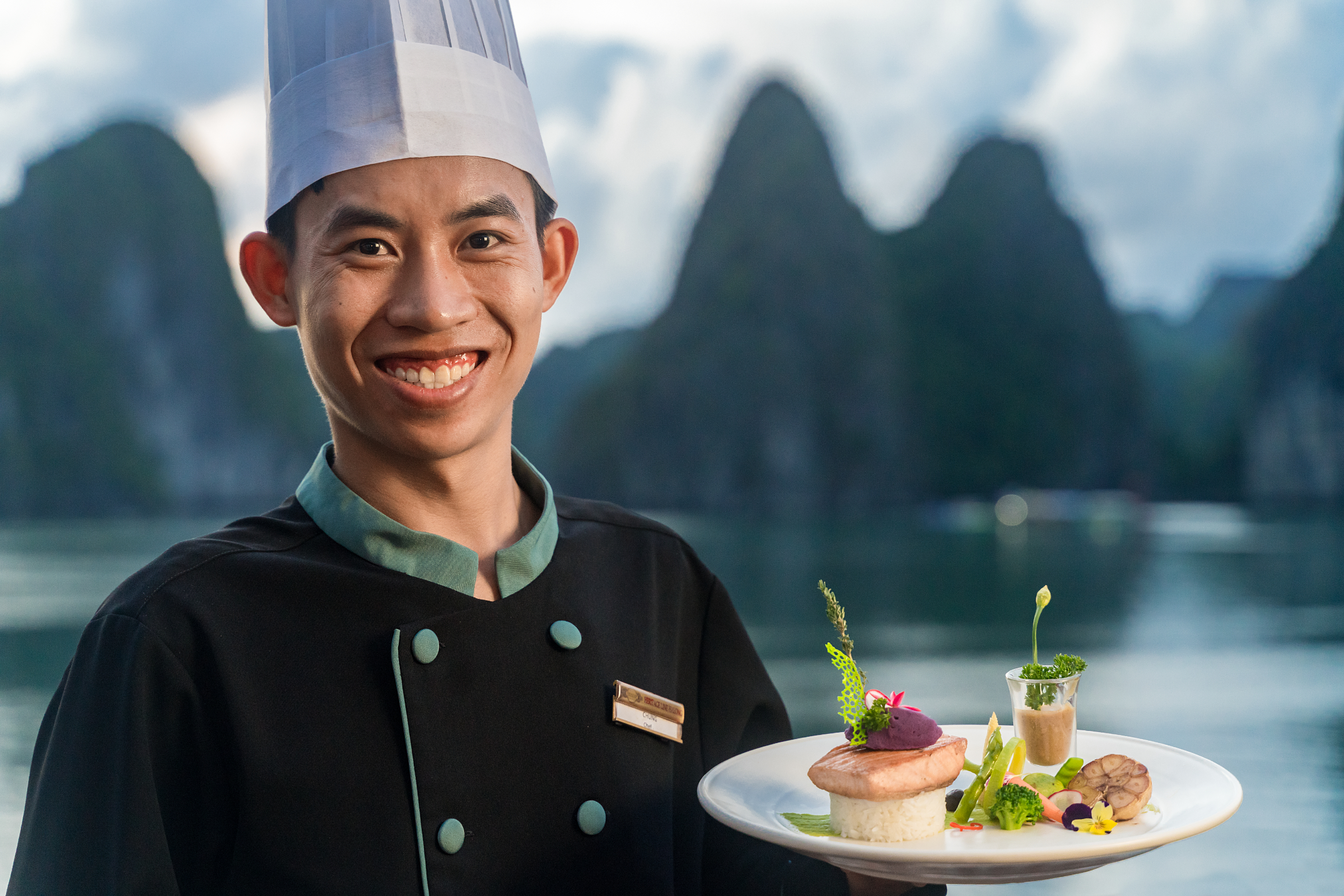 Chef with plate of food at Halong Bay, Vietnam